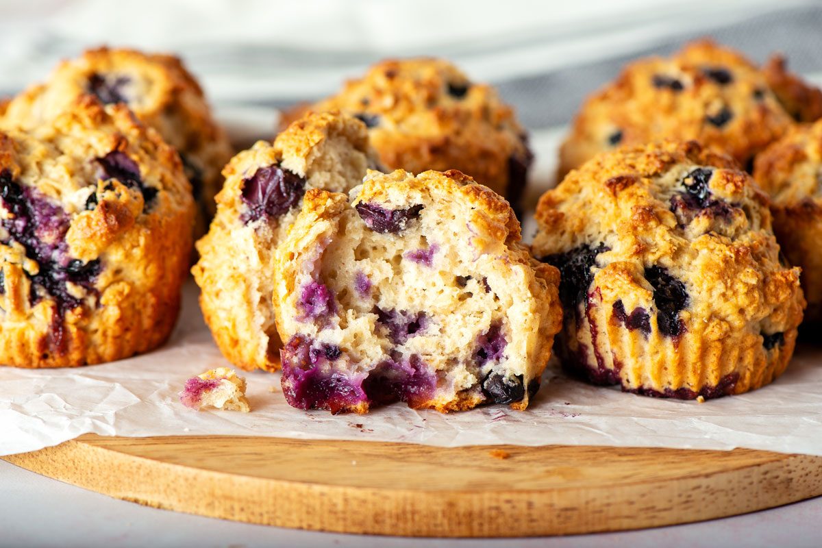Close up of opened Soft Blueberry Oatmeal Muffins on a wood board.