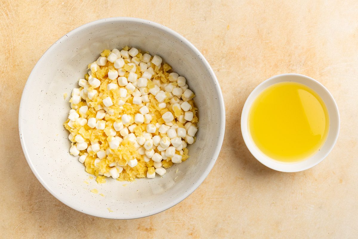 Taste of Home Taffy Apple Salad recipe photo of the marshmellows and crushed pineapple in a mixing bowl with the reserve juices on the side.