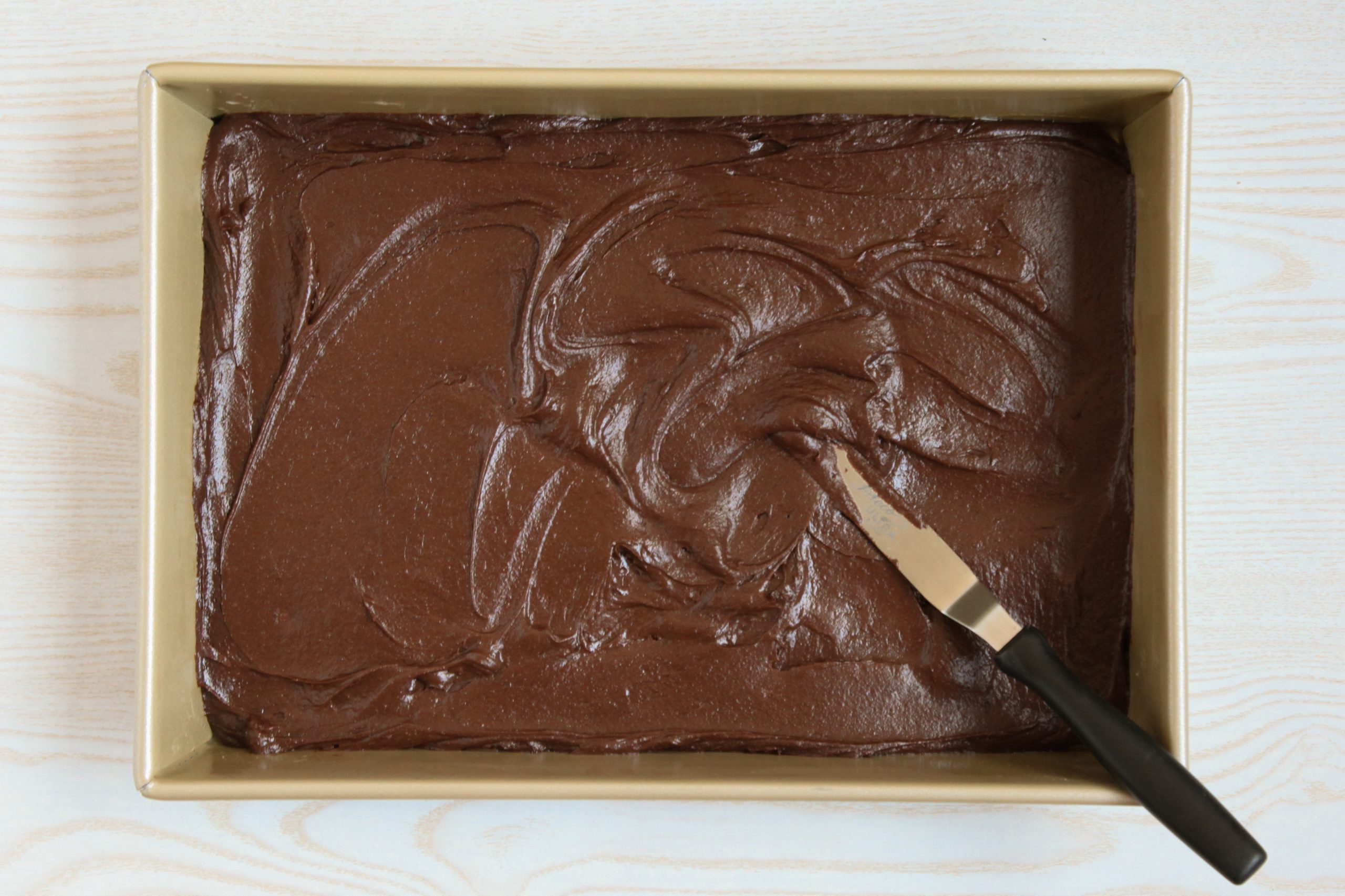 Spreading brownie batter into a baking pan