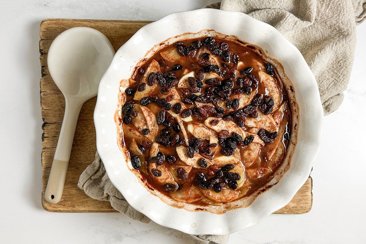 Taste of Home Baked Apple in a pie plate on a wooden board