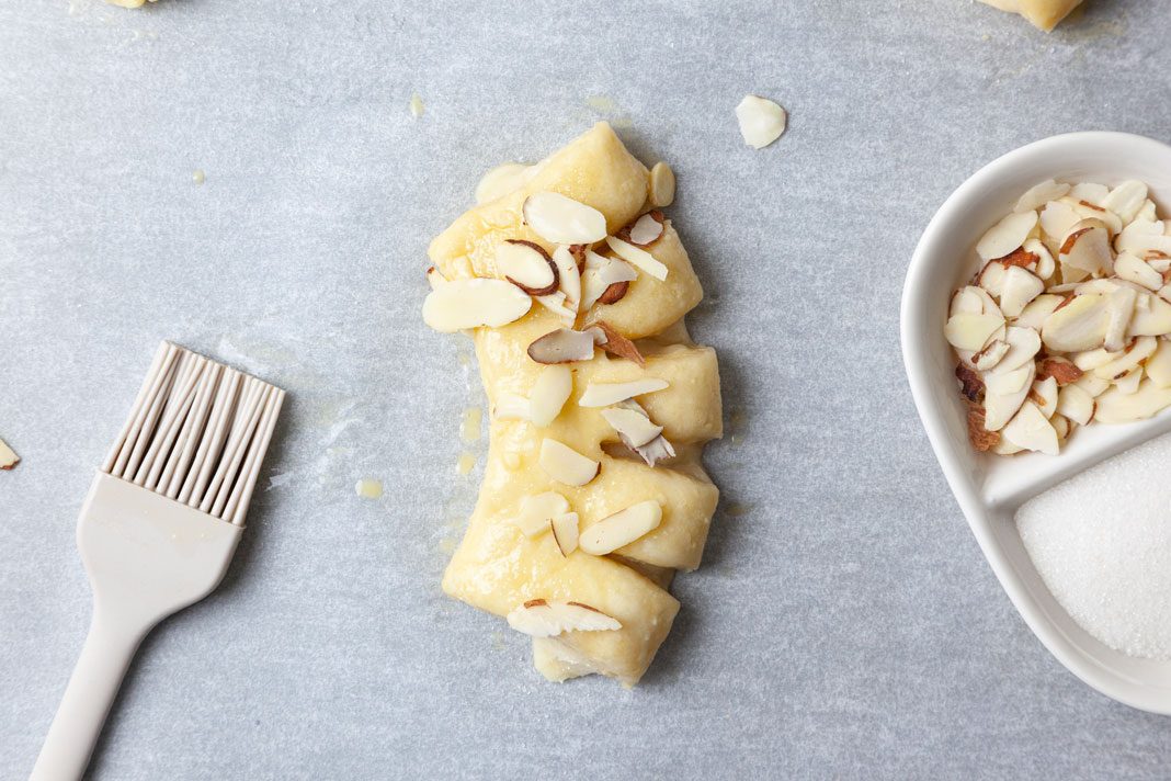 Step 6 of Taste of Home Bear Claw is to beat the water and remaining egg. Brush the mixture over the dough. Sprinkle with the sugar and almonds. Bake until golden brown, for about 15 minutes. Remove from the pans to wire racks to cool.