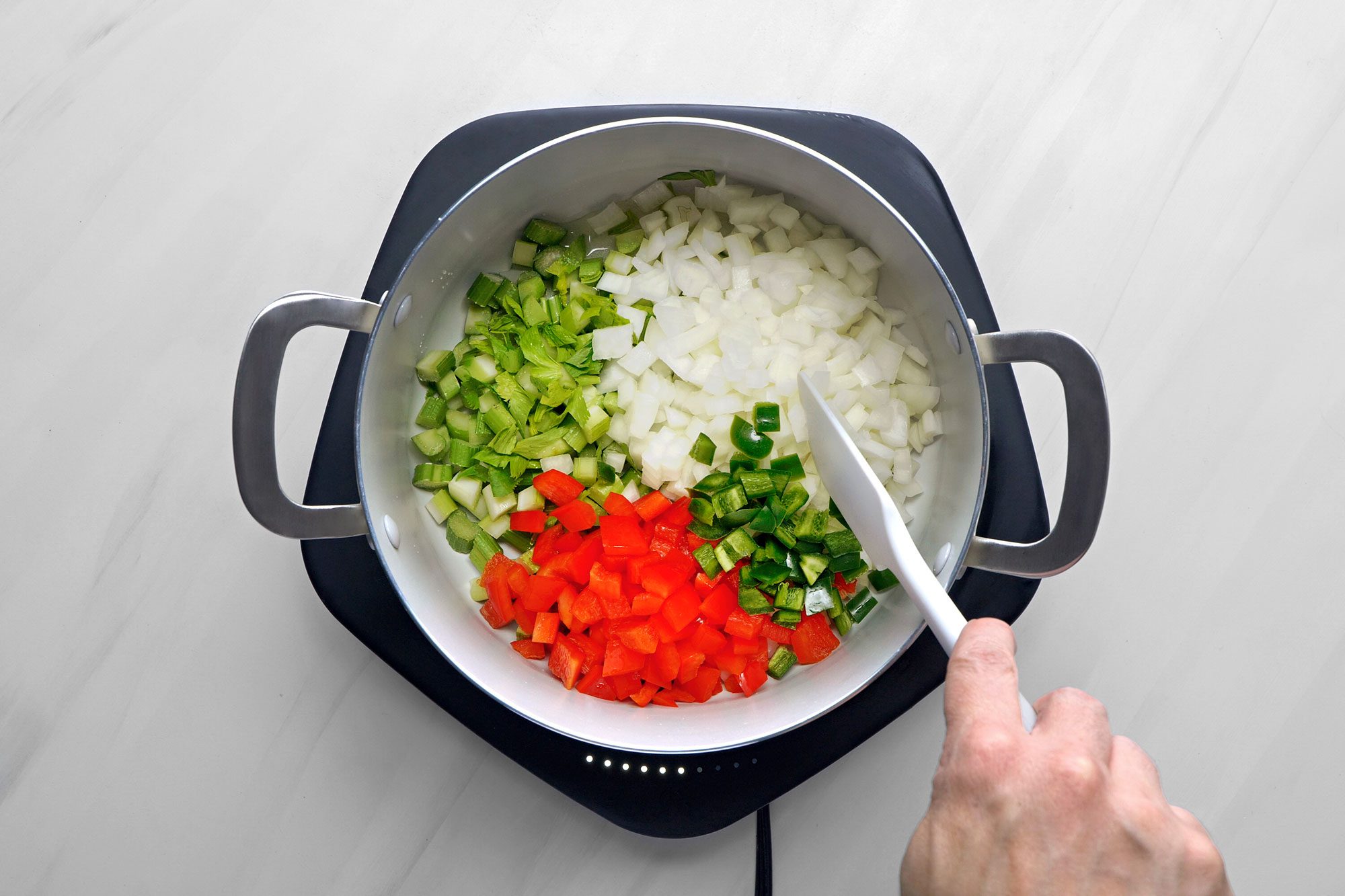 In a large saucepan, saute the celery, onion, red pepper and jalapeno in oil until tender.