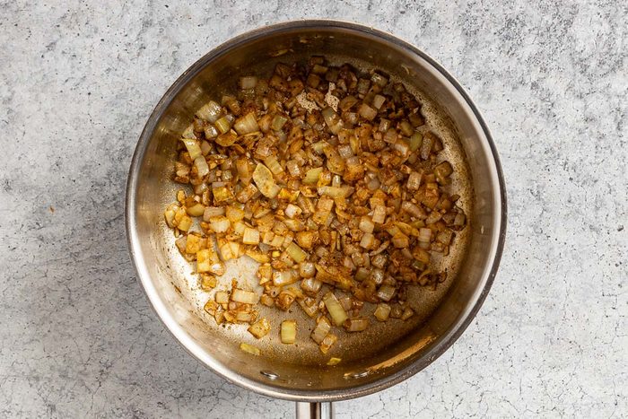 Taste of Home Black Beans and Rice photo of the sauteed onion, garlic and seasonings in a small saucepan.