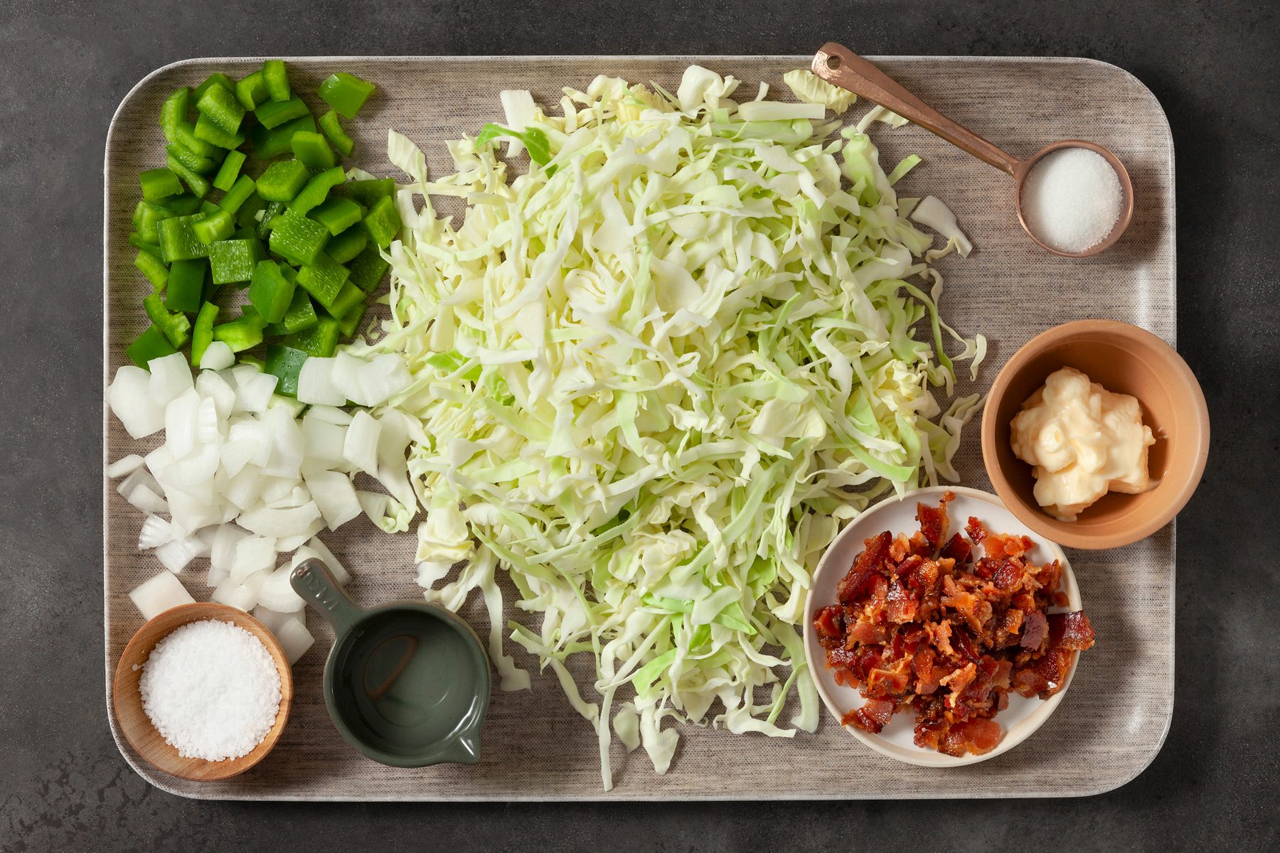 overhead shot; dark grey background; Favorite Cabbage Salad ingredients placed in a tray over background