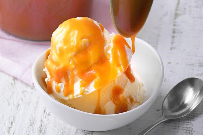 3/4th shot of caramel sauce poured on vanilla ice cream
