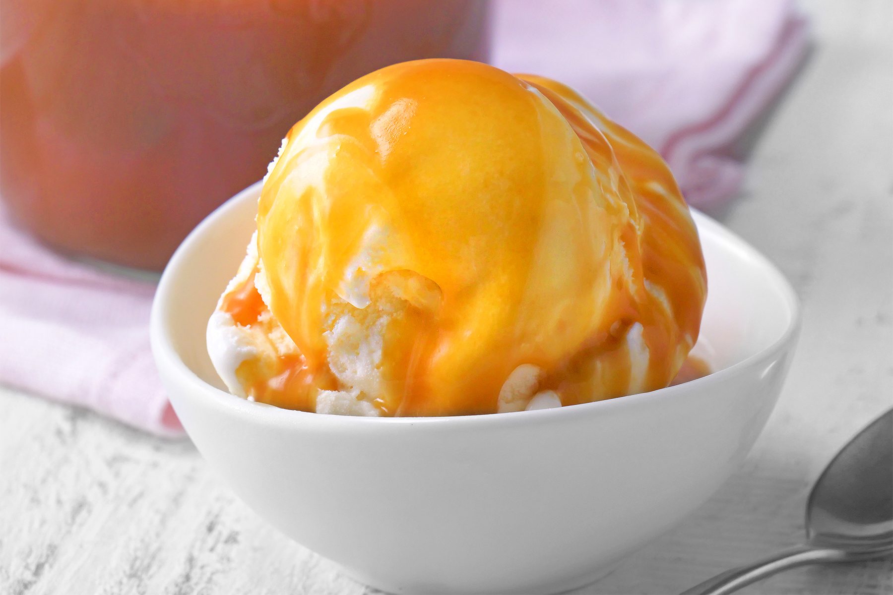 close shot of caramel sauce poured on vanilla ice cream