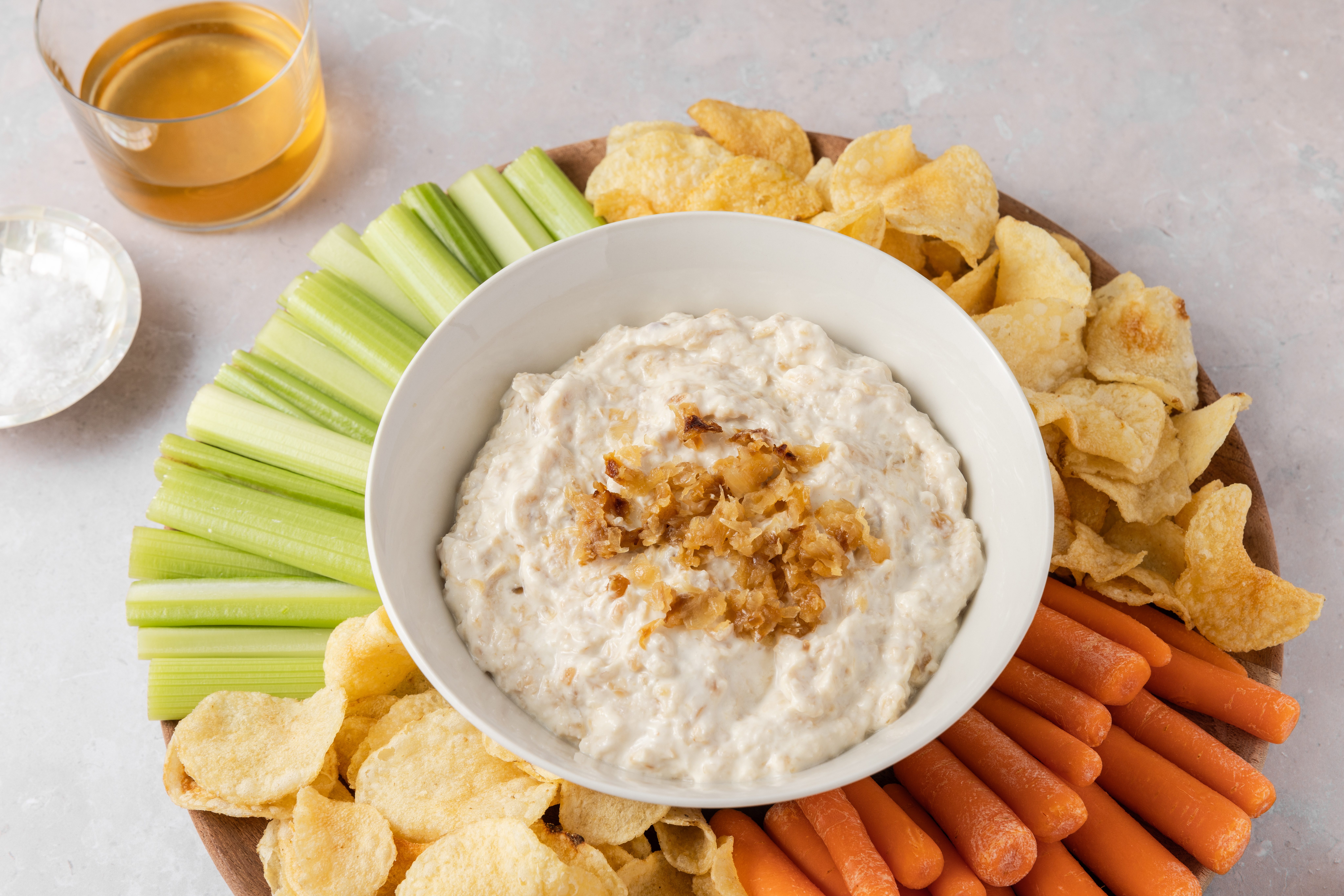 Caramelized onion dip served with fresh vegetables and potato chips.