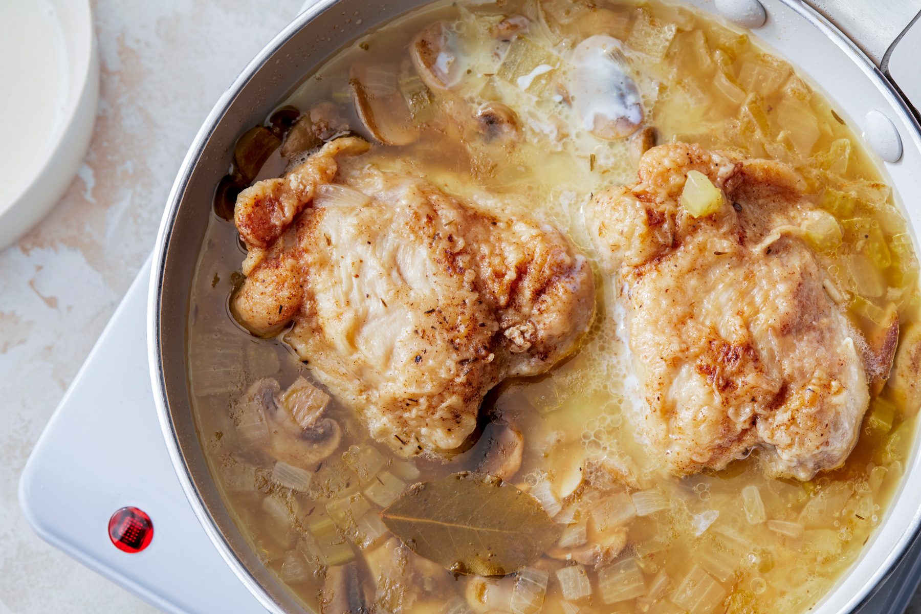 overhead shot; white textured background; Added cream mixture to skillet