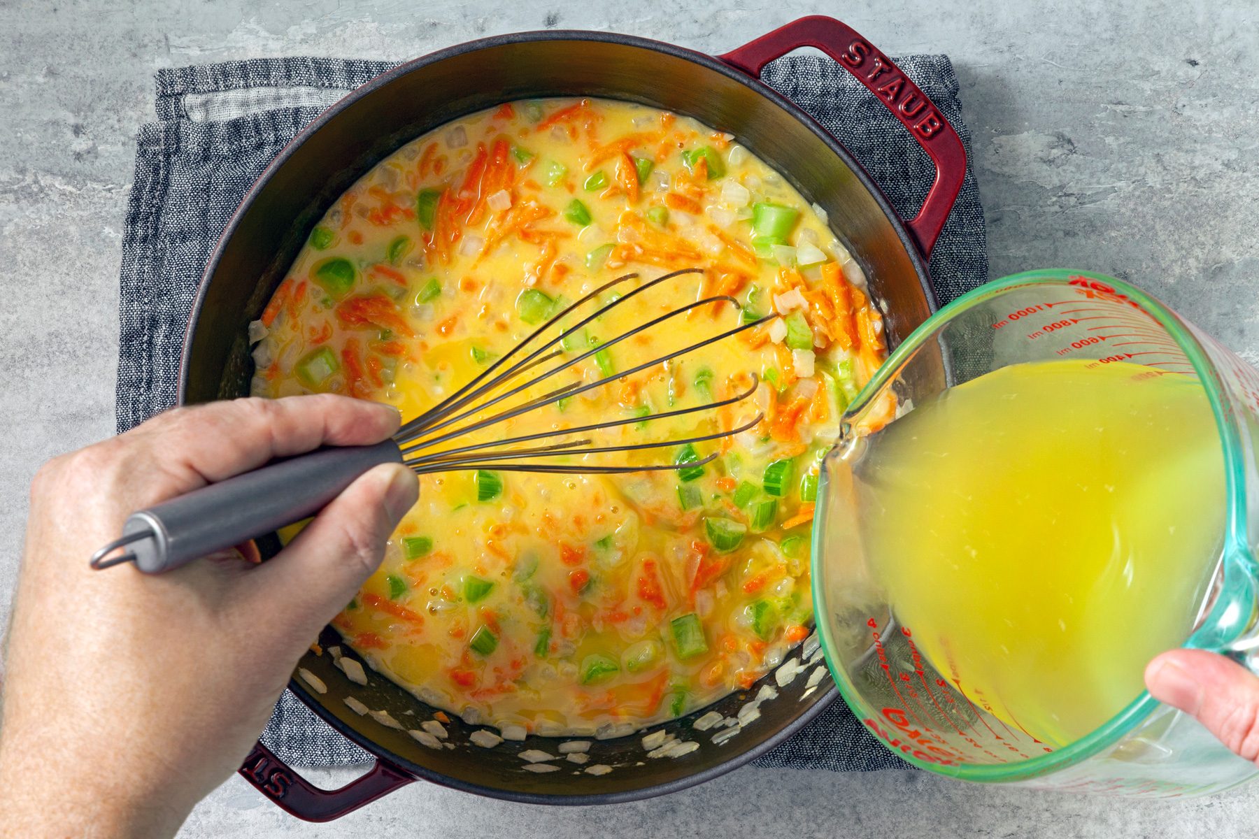 top view shot of mixing broth with vegetables in pot