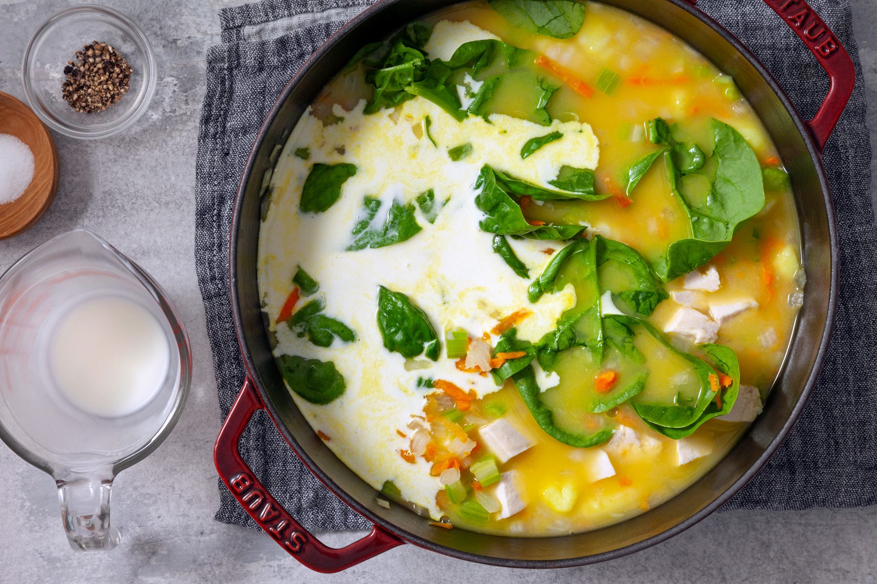 adding cream and spinach to finish the soup 
