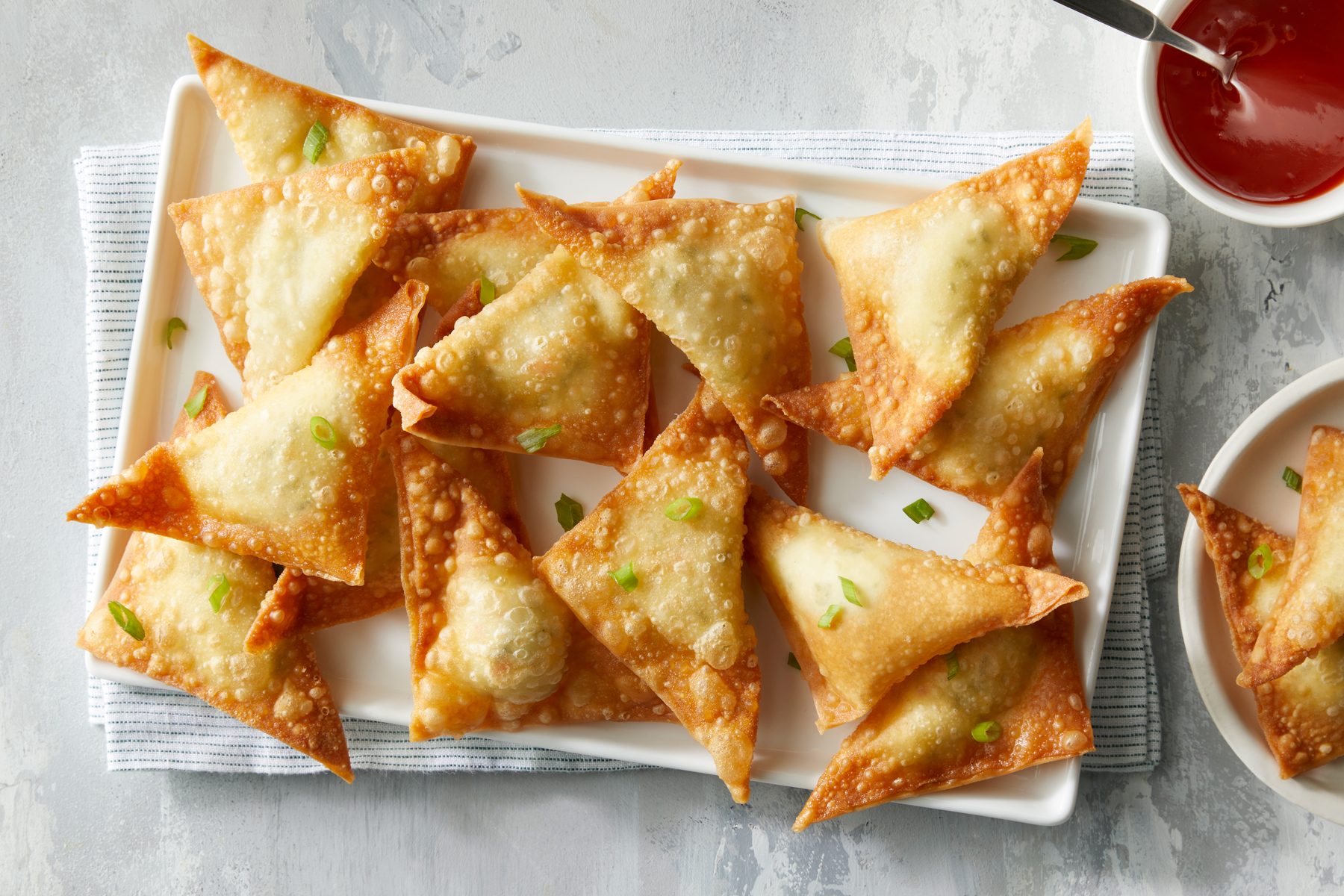 Crab Rangoon on serving platter with sauce