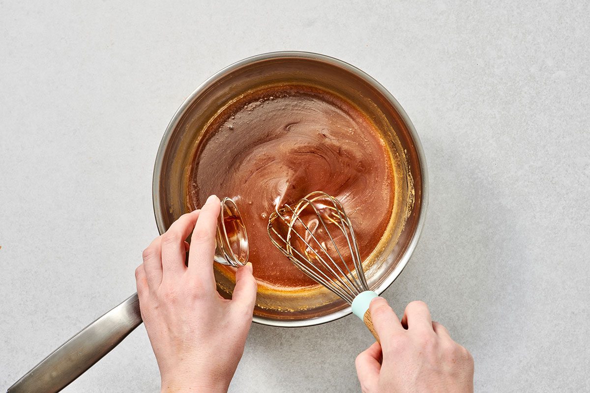 Stirring vanilla extract into the mixture 