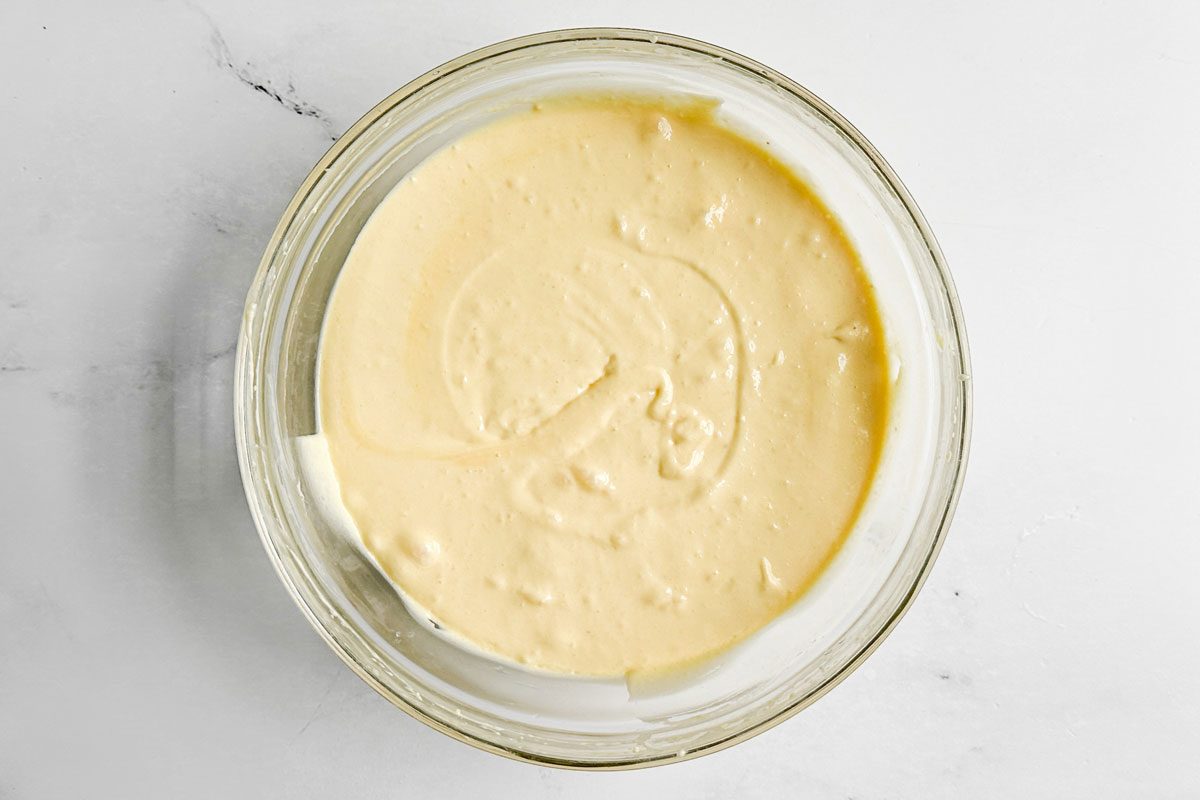 Batter for Taste of Home Honey Bun Cake in a glass bowl on a marble surface