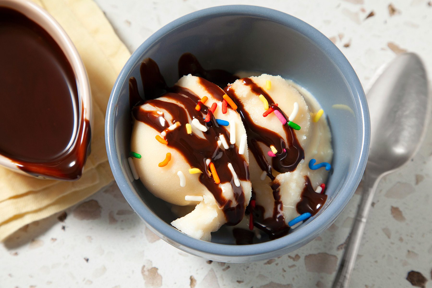 3/4th shot of vanilla ice cream in a bag topped with sprinkler and syrup