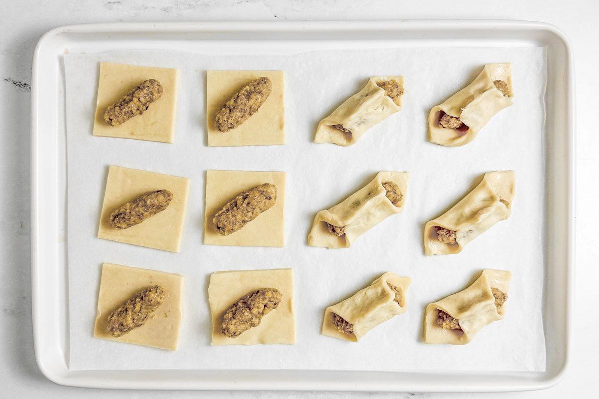 Unbaked Taste of Home Kolacky Cookies on a white baking sheet on a marble surface