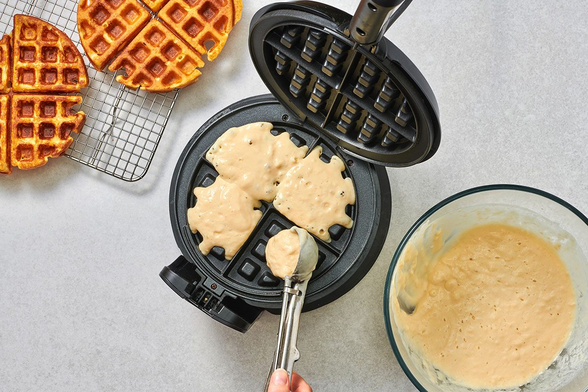 Pouring buttermilk waffle batter onto a waffle iron