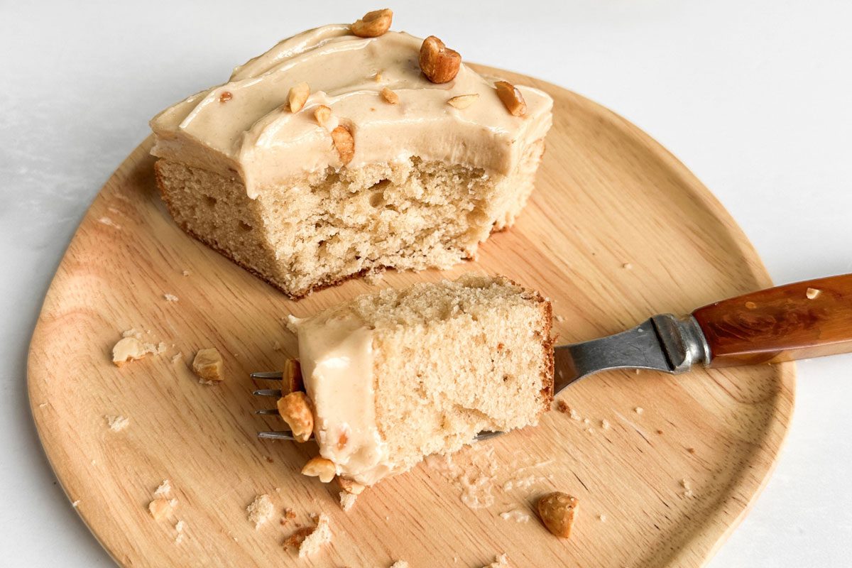 Taste of Home Peanut Butter Cake on wooden board and plate on a marble surface