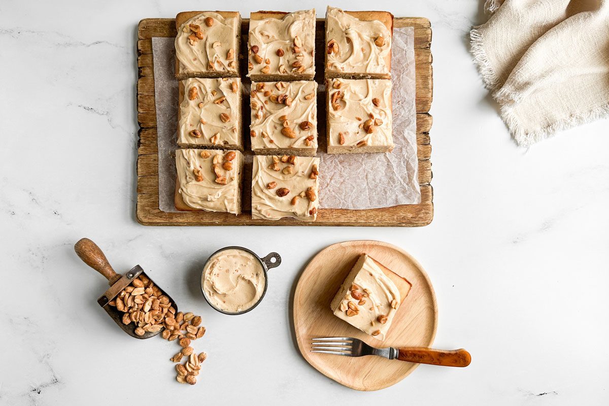 Taste of Home Peanut Butter Cake on wooden board and plate on a marble surface