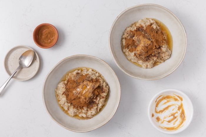 Toppings being added to the oatmeal served in bowls.
