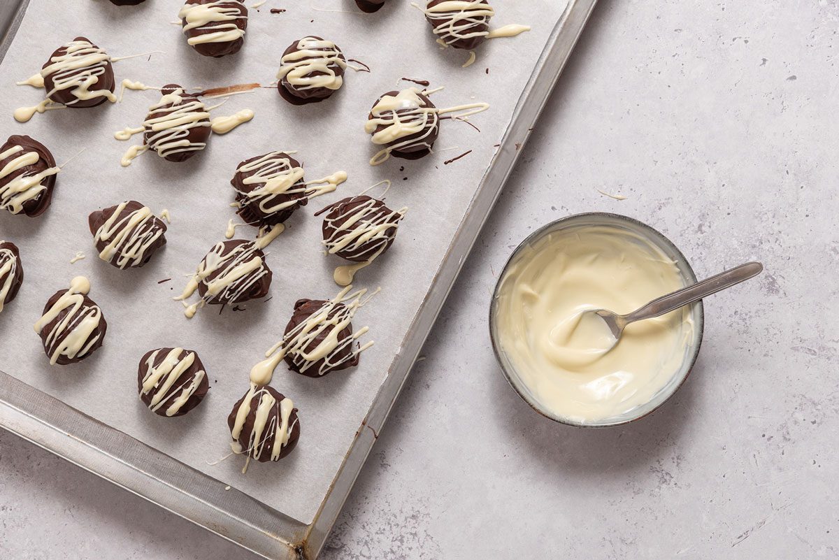 Chocolate peanut butter balls drizzled with white chocolate