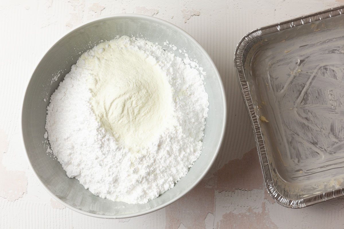 Step 1 of Taste of Home Pecan Logs is to butter a square 8-inch pan with 2 teaspoons of the butter and set it aside. Combine the confectioners’ sugar and milk powder in a small bowl and set that aside as well.