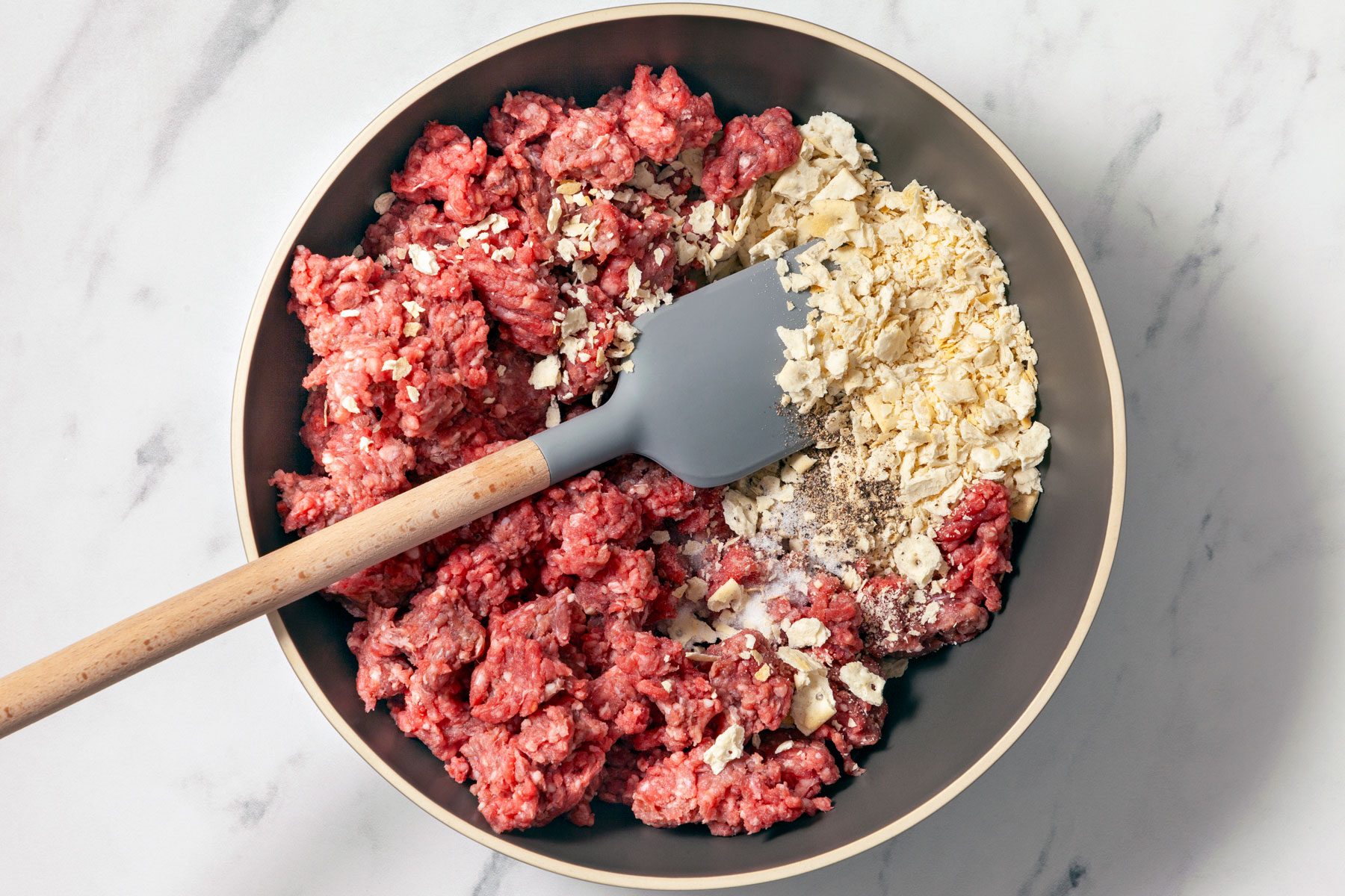 Cracker crumbs, water, salt and pepper mixed in a bowl.