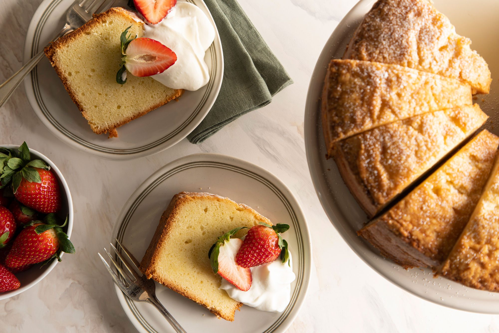 Pound Cake sliced and served in plates with strawberries on the top
