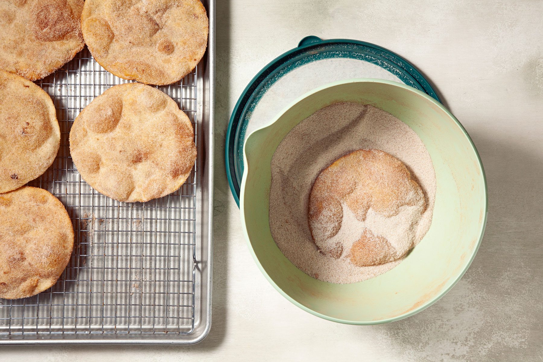 Fried tortilla being coated in cinnamon.