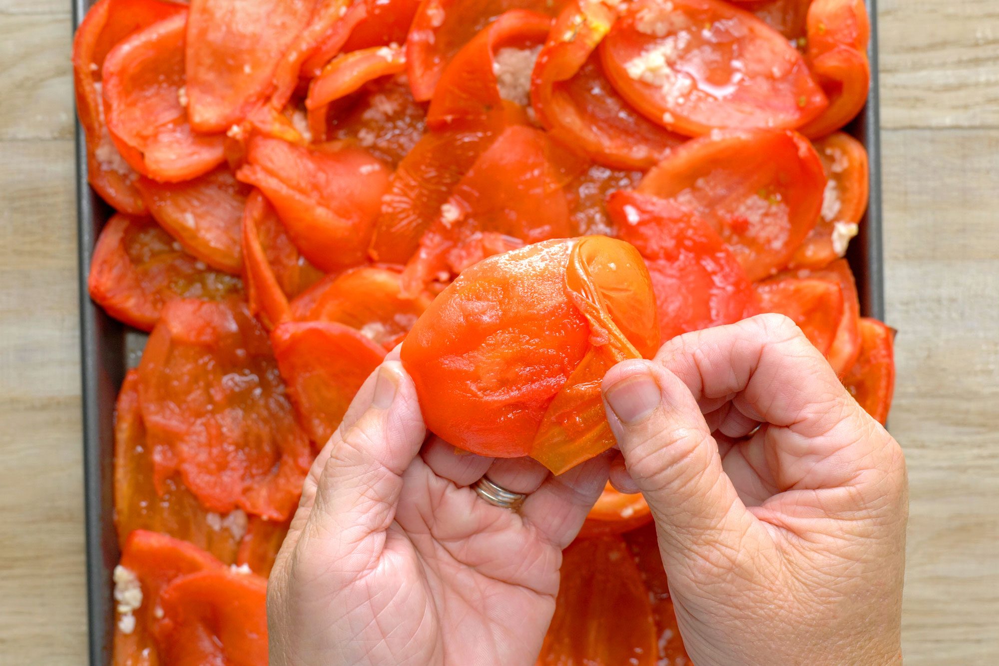 Remove and discard skins of tomatoes; Wooden Background;