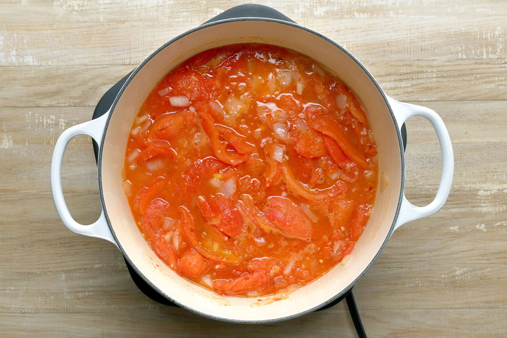 Add tomatoes, water, salt and, if desired, pepper flakes. Bring to a boil; Wooden Background;