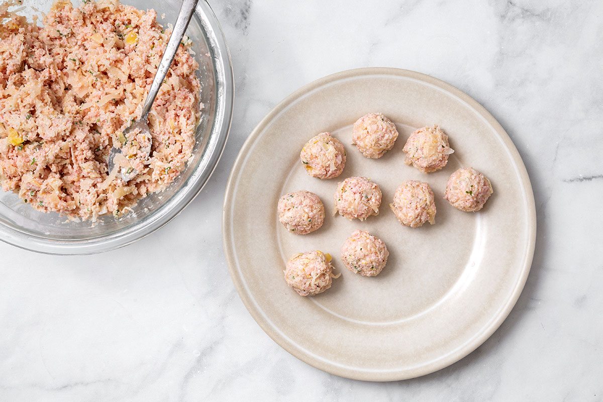 Sauerkraut mixture rolled into balls on a plate for step 3 of Sauerkraut ball recipe for Taste of Home
