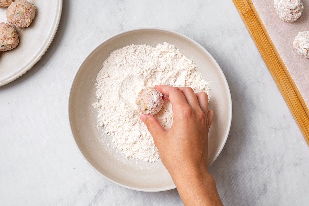 Rolling sauerkraut ball mixture in flour for step 4 of Sauerkraut Ball recipe for Taste of Home