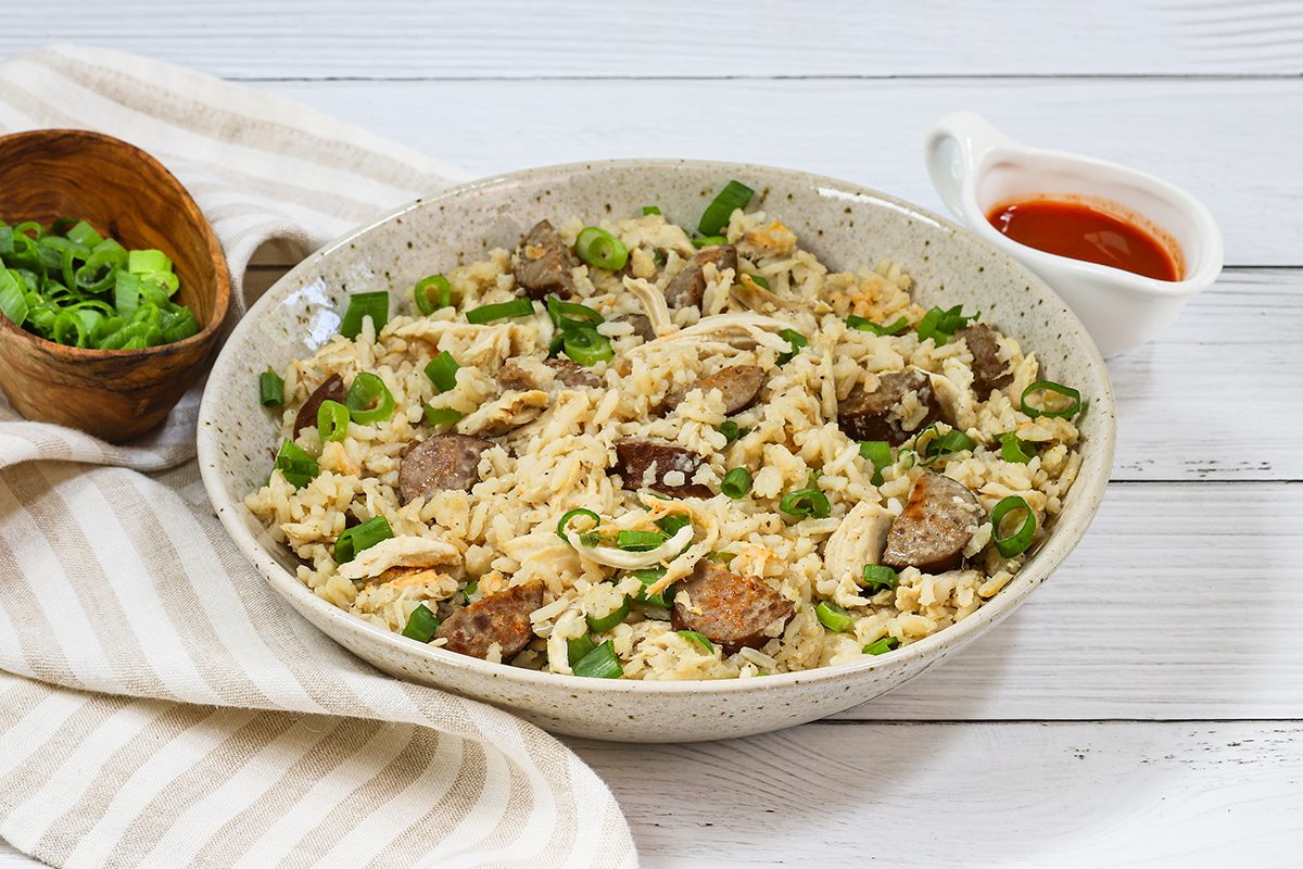 Slow Cooker chicken bog with smoked sausage, rice, and green onions, in a bowl.