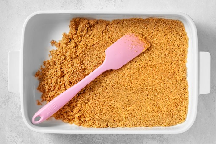 overhead shot of fine crumbs spreaded in the botton of greased baking pan