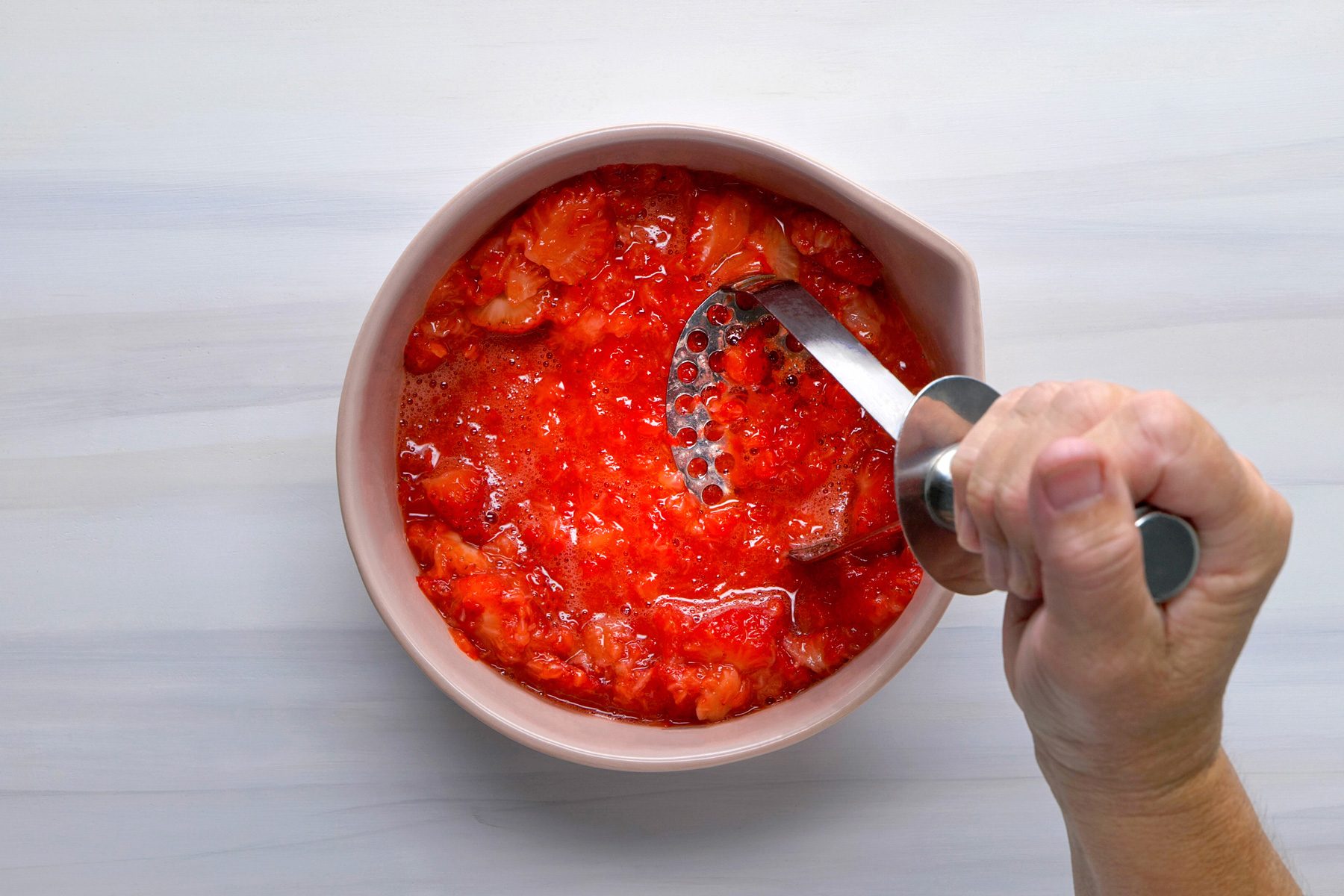 Overhead shot of crush strawberries; induction; wooden surface