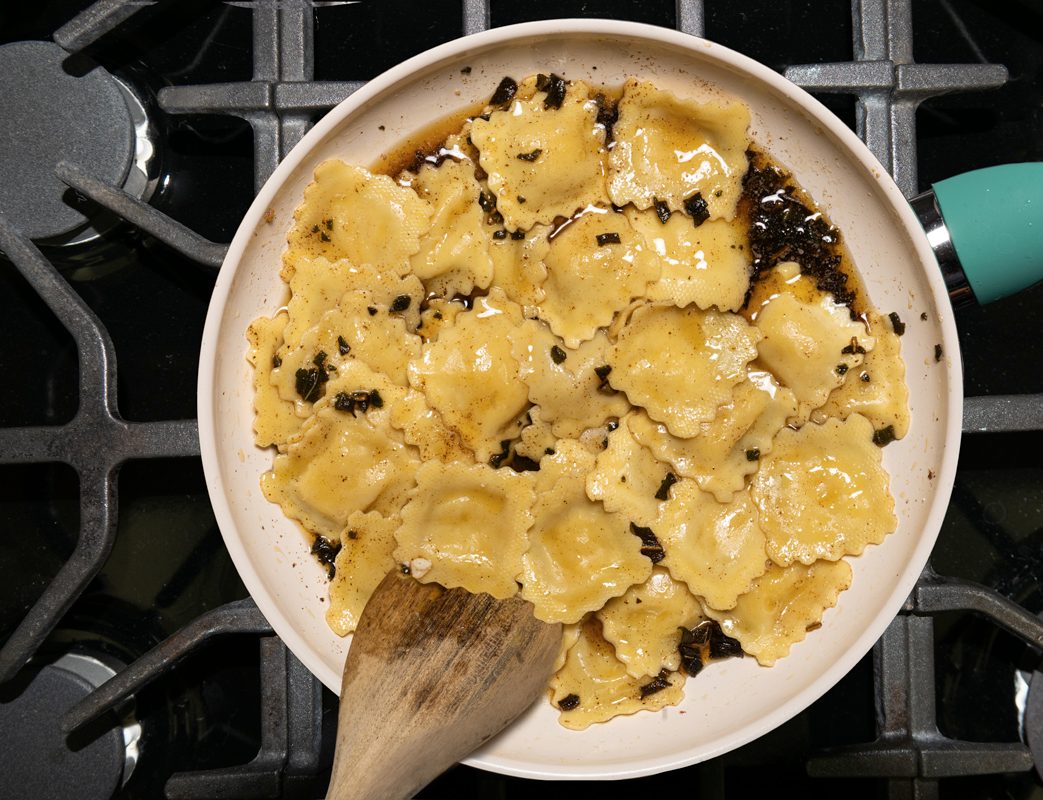 Mixing the sauce with the ravioli