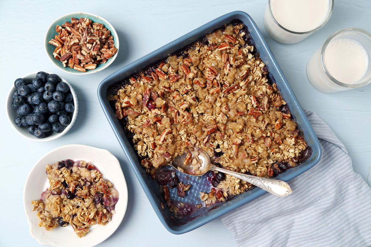 Process of making Taste of Home's Blueberry Baked Oatmeal in small dishes on a light blue surface.