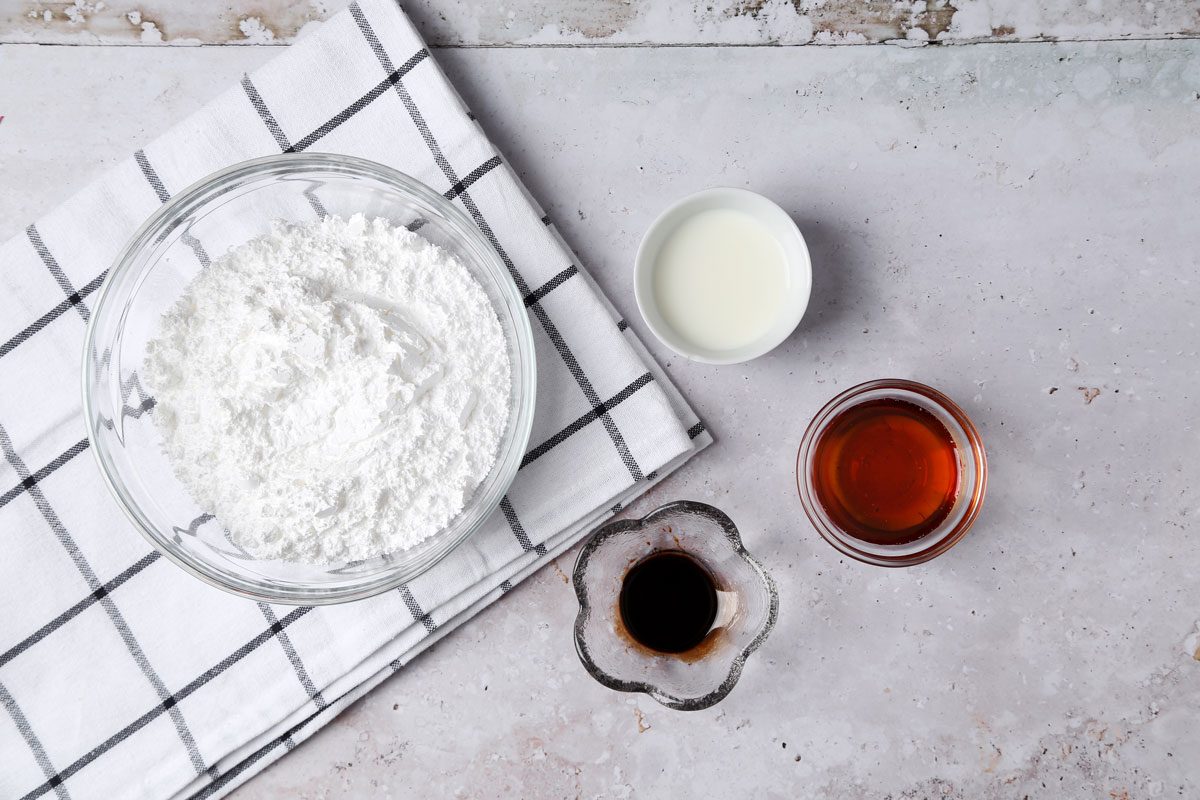 Ingredients for Taste of Home's Maple Glaze laid out in small bowls on a grey marble surface.