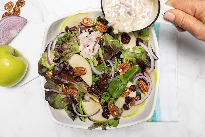 Pouring the dressing over the salad