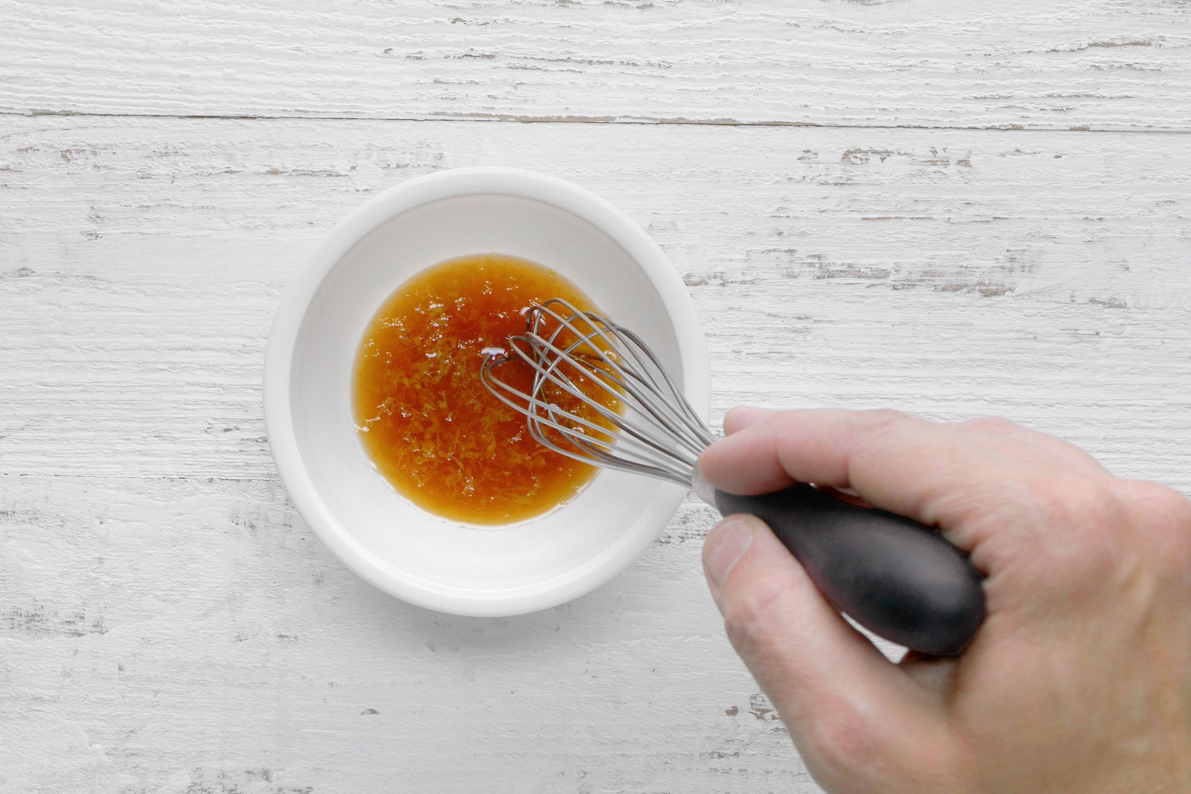 Brandy, lemon zest and vanilla extract in a bowl