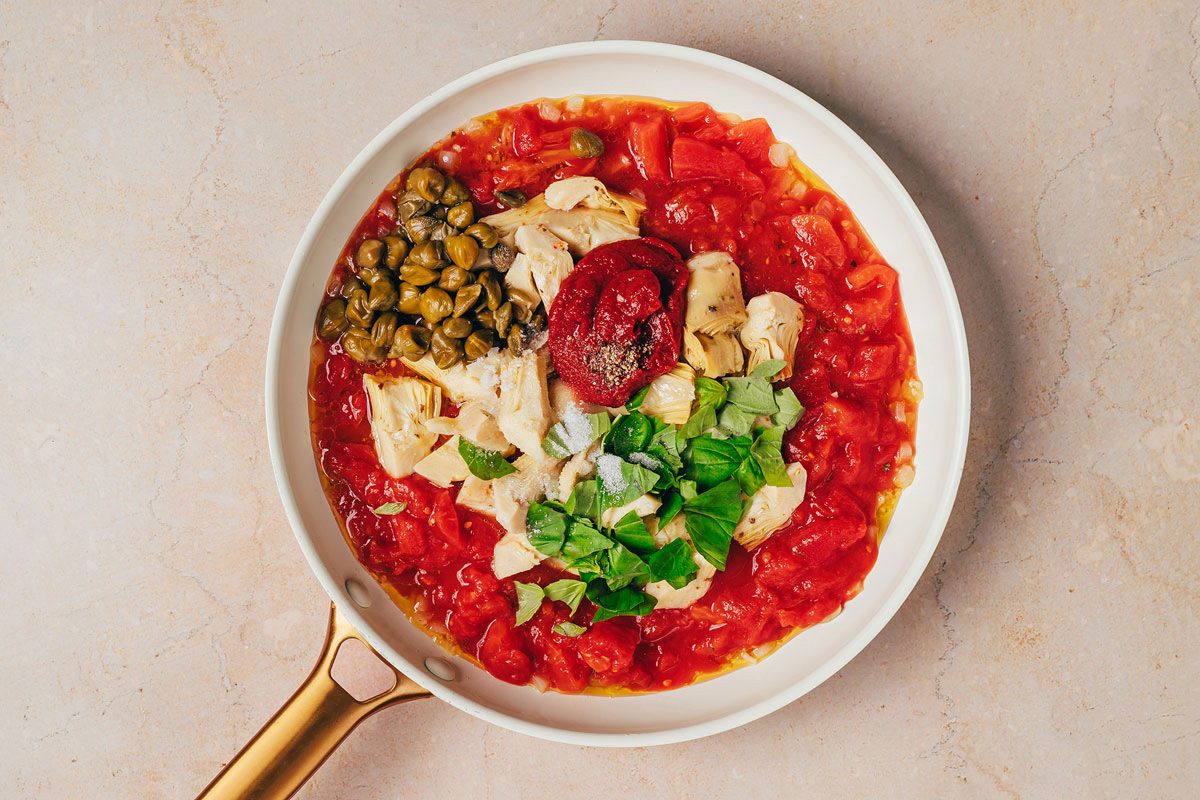 Ingredients for Artichoke Tomato Pasta sauce combined in a large skillet a recipe by Taste of Home