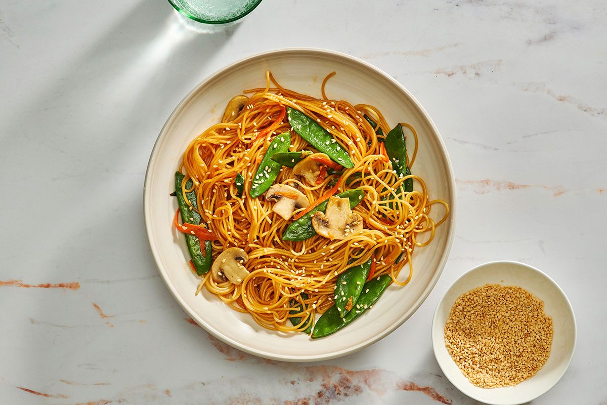 Asian spaghetti served in a bowl garnished with toasted sesame seeds