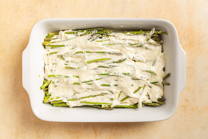 Taste of Home Asapargus Casserole photo of the cream sauce poured over the top of the asparagus.