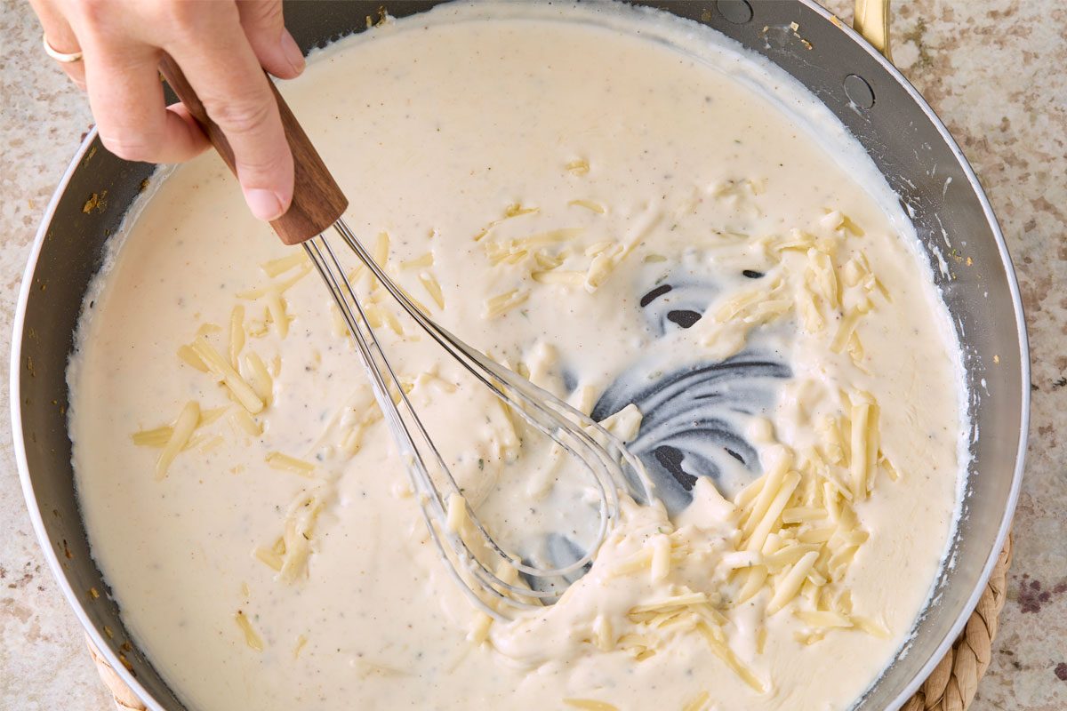 Overhead Shot Of Stir In cheese; Whisk Tool; Marble Surface