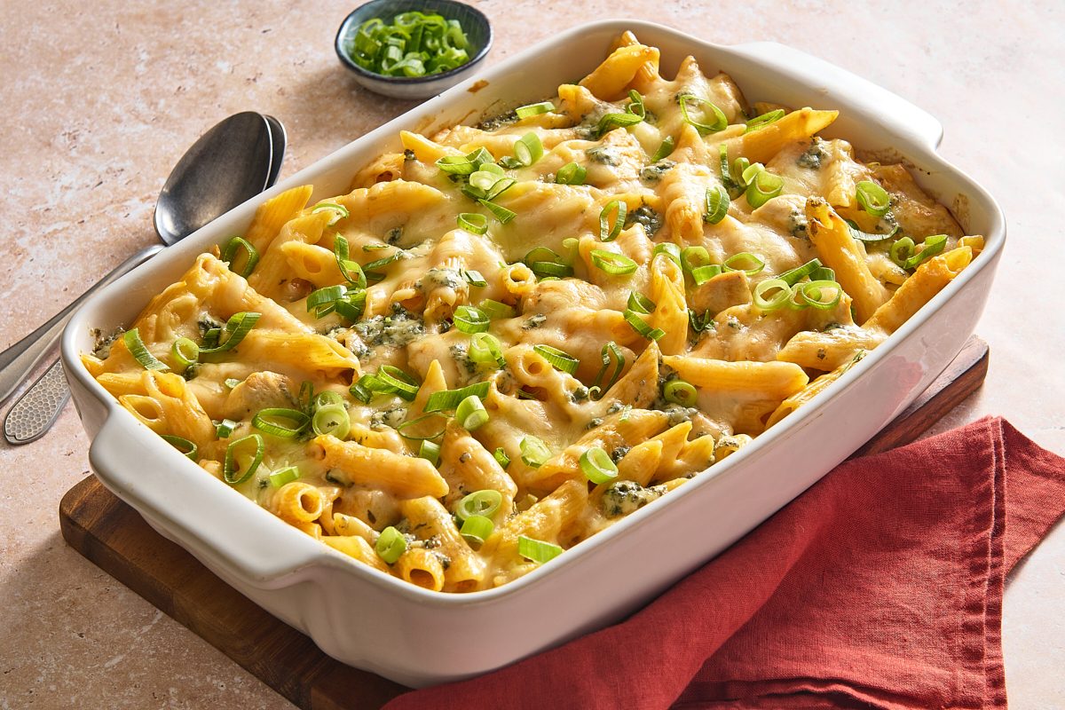 Angled shot of buffalo chicken casserole in a baking dish topped with green onions