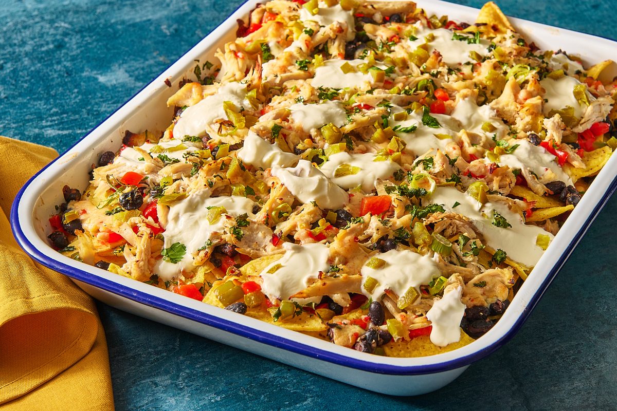Closeup of chicken nachos baked in a large baking tray