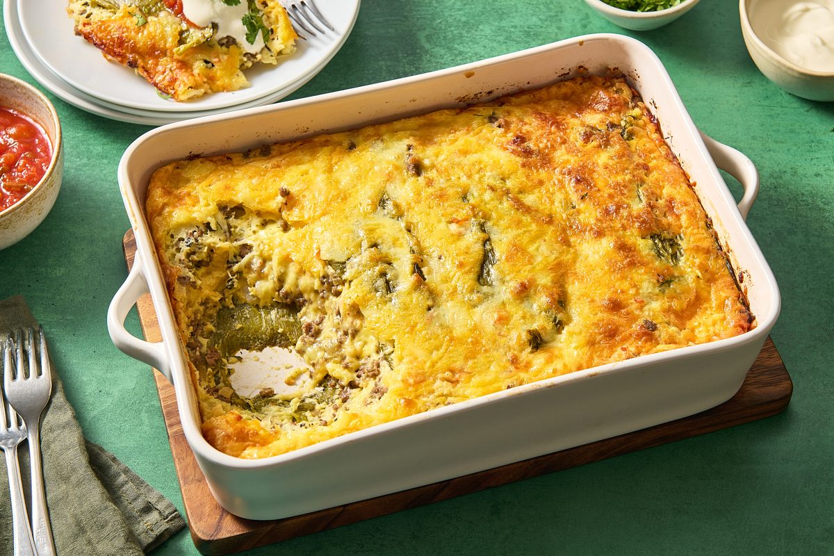 Angled shot of Chile relleno casserole in a baking dish with a portion scooped out