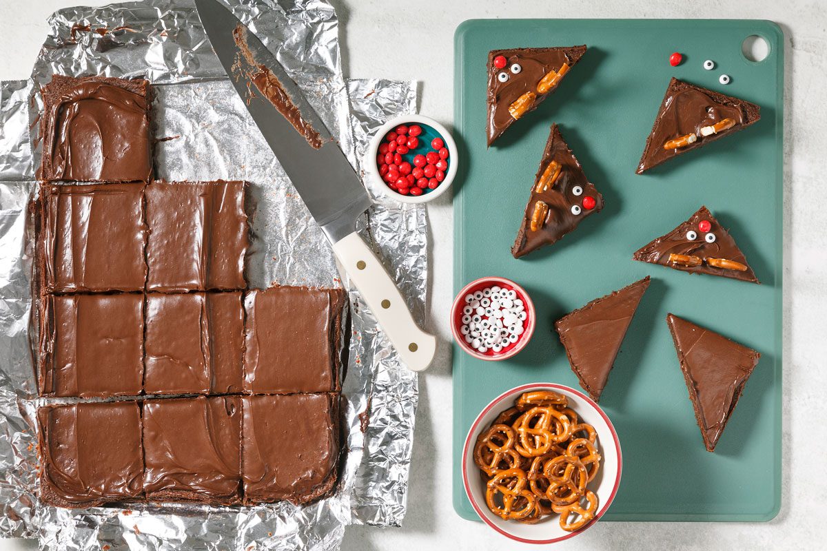 overhead view of various steps in the decorating process: cut the brownies, add pretzels and candies for the antlers and faces