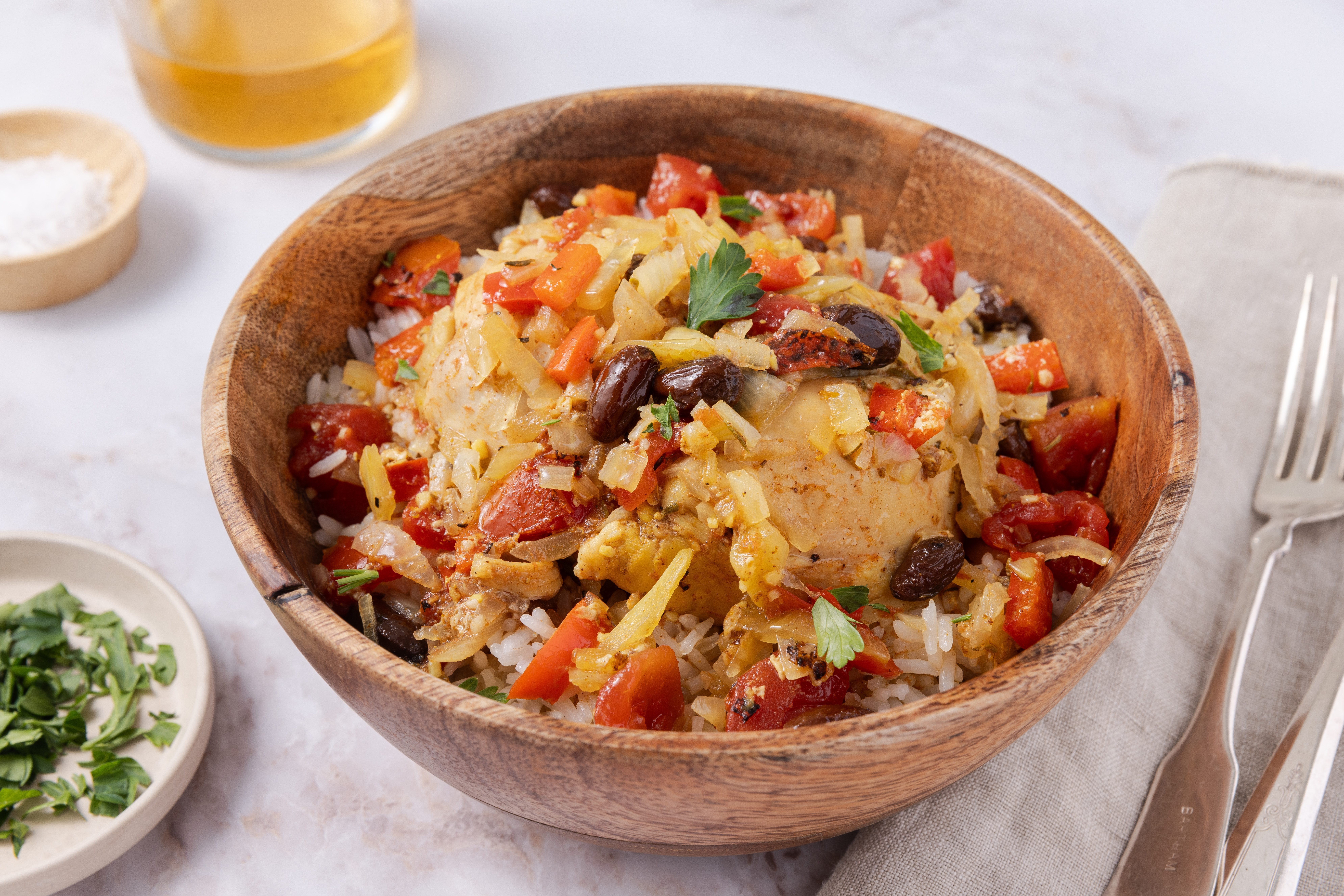 Country captain chicken ready and served in wood bowl with rice.