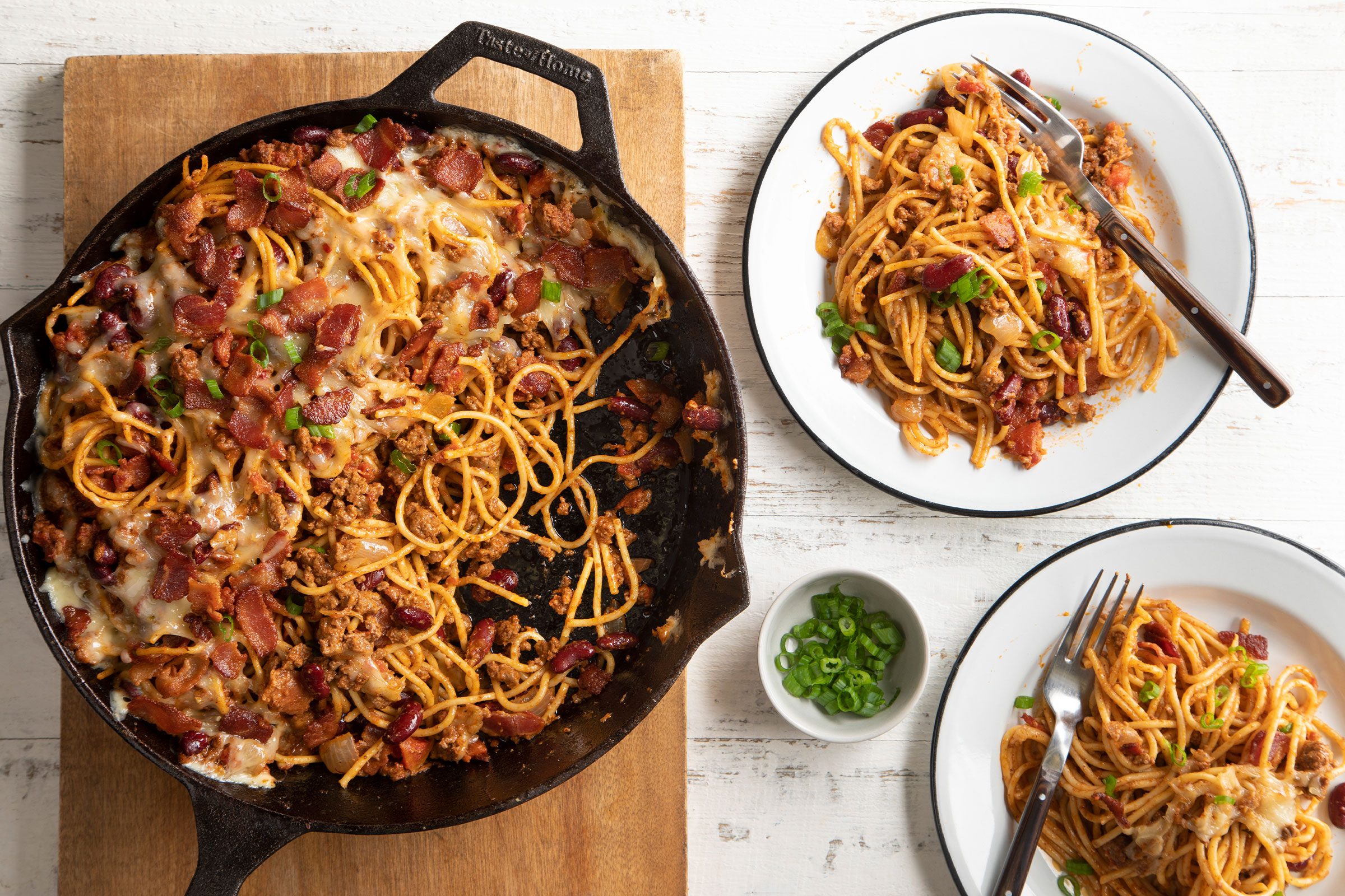 Cowboy Spaghetti made in a cast iron skillet and served in white plates